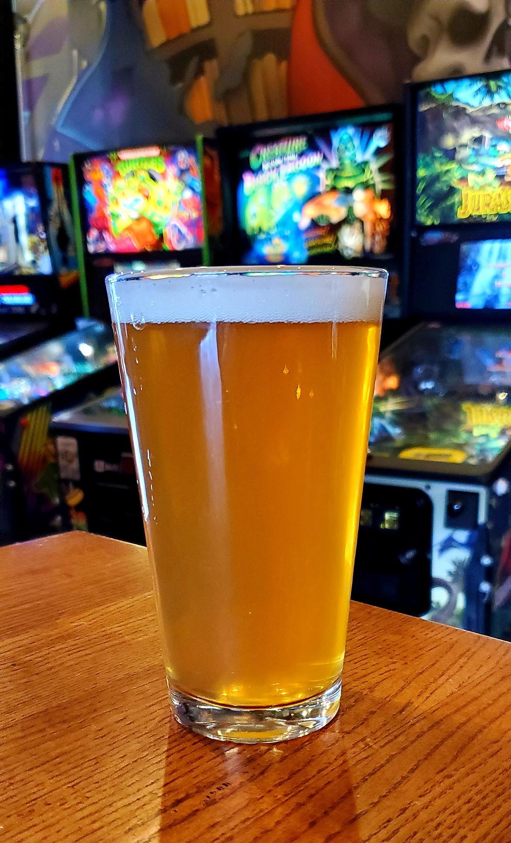 Feelin Easy #2 Sour Ale w/ Strawberry Brewed at Lovedraft's Brewing Co In Mechanicsburg Pennsylvania Perched in front of several pinball and arcade machines at the Lovedraft's brewhouse